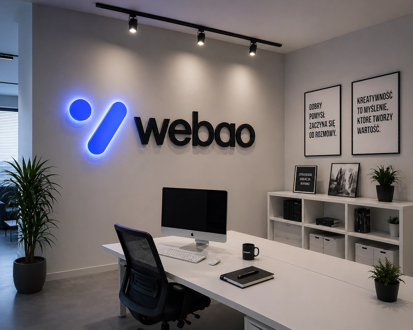 Biuro WEBAO — stanowisko pracy i logo na ścianie